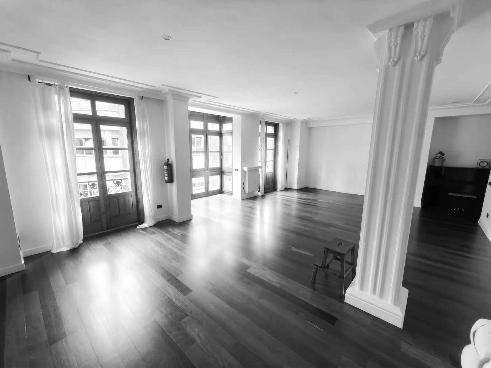 Shala de Yoga - salón diáfano con columnas clásicas, suelo de madera y balcón